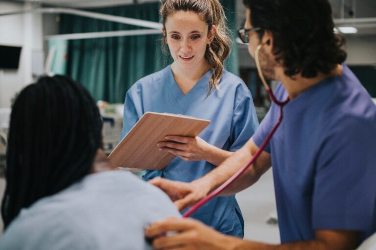 Junger männlicher Arzt, der einen Patienten untersucht
